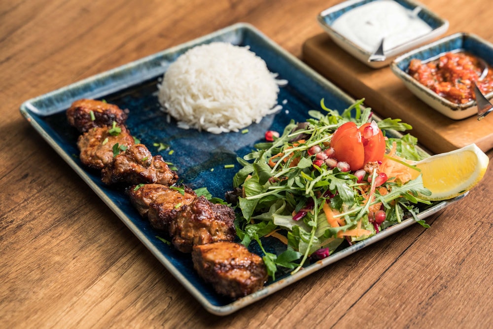 Charcoal-grilled meat skewers with rice and fresh salad at Turkuaz Brasserie